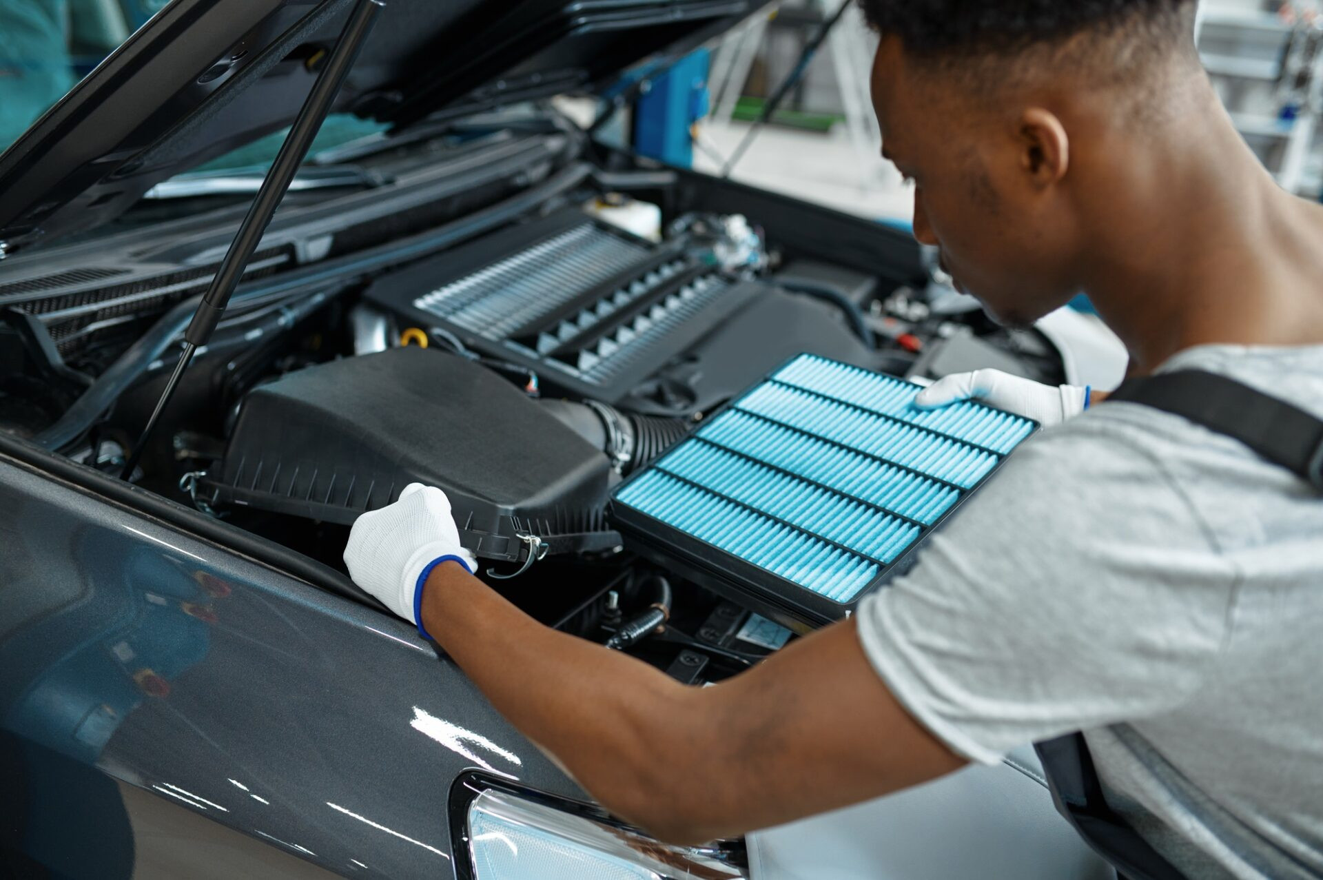 Le mécanicien mâle change de filtre à air, service de voiture. 