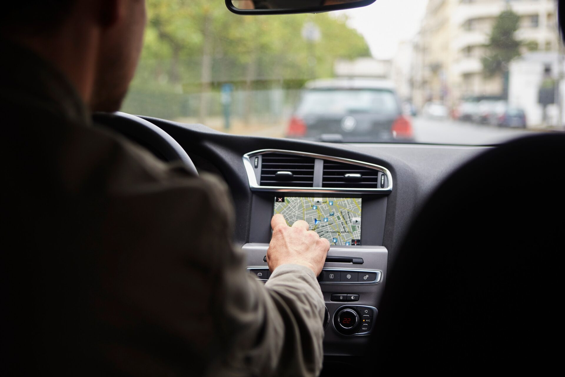 Homme adulte au milieu de l'adulte assis en voiture, en utilisant le GPS