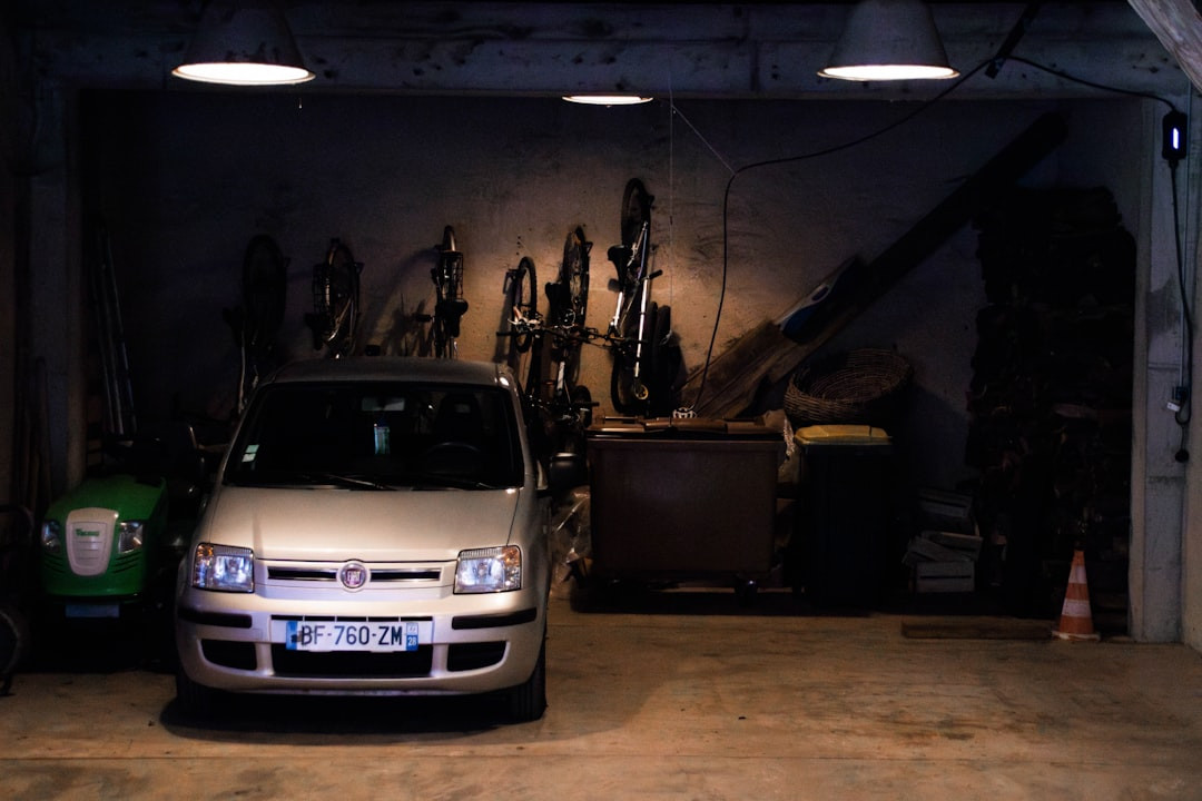 Une voiture est garée à l'intérieur d'un garage sombre et encombré.