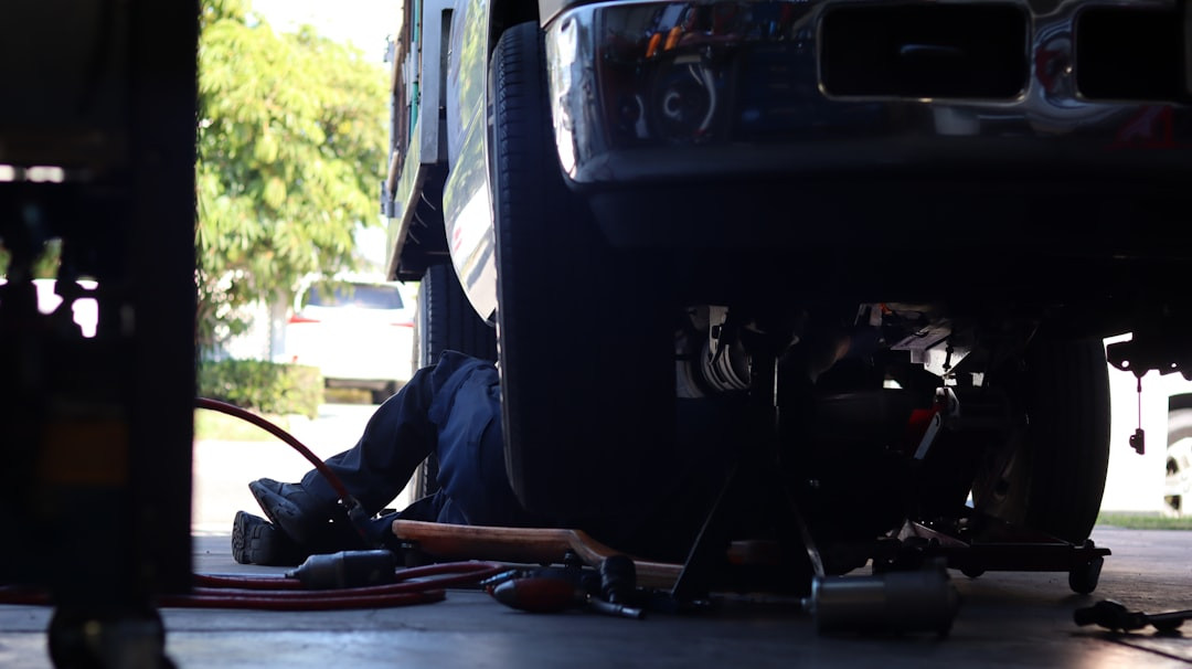 un homme travaillant sur un véhicule sous un camion
