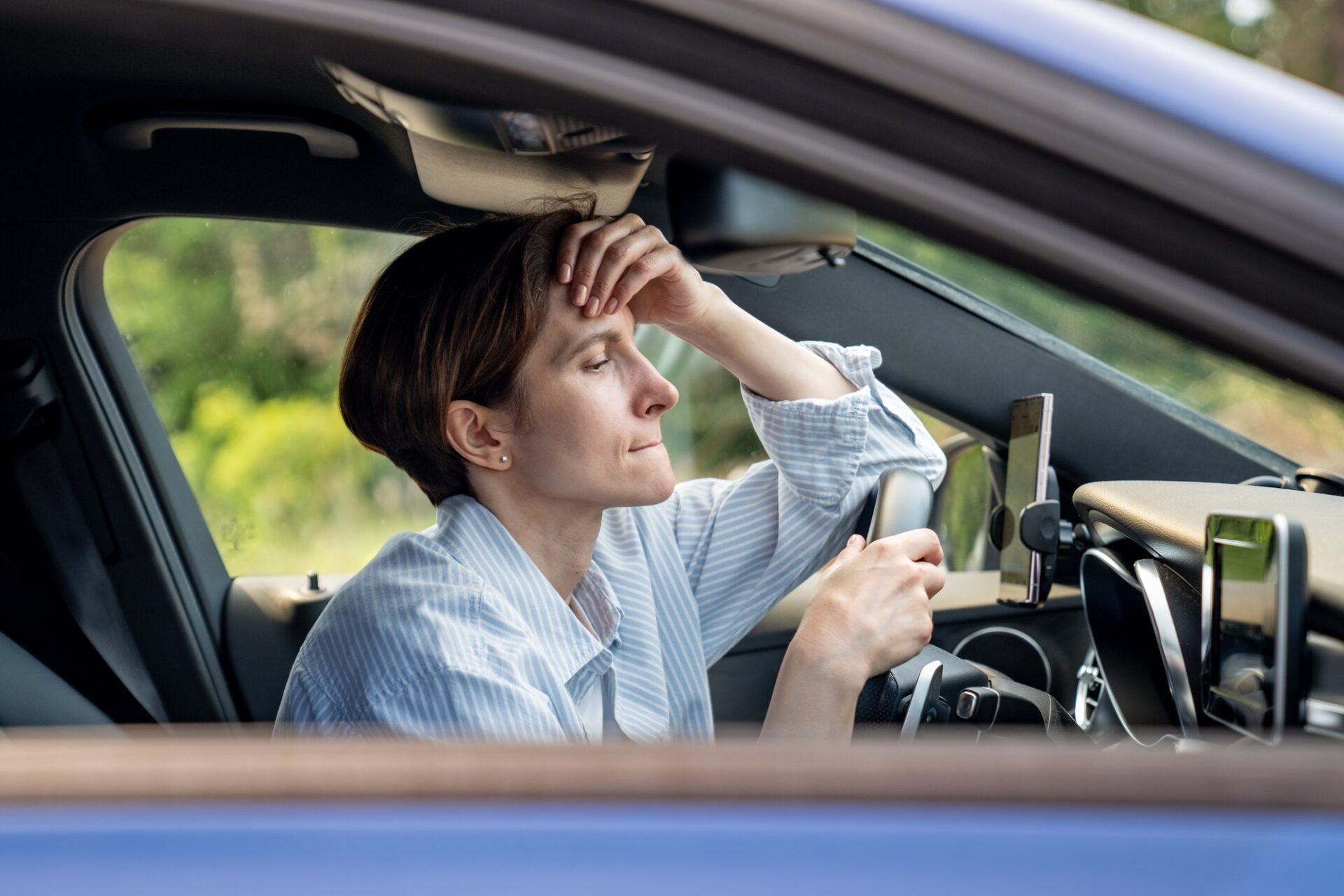 Une femme d'âge moyen stressé conduisant une voiture à avoir des problèmes sur la route en regardant vers l'avenir. 