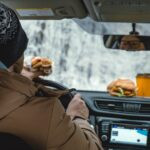 L'homme mange en conduisant une voiture.