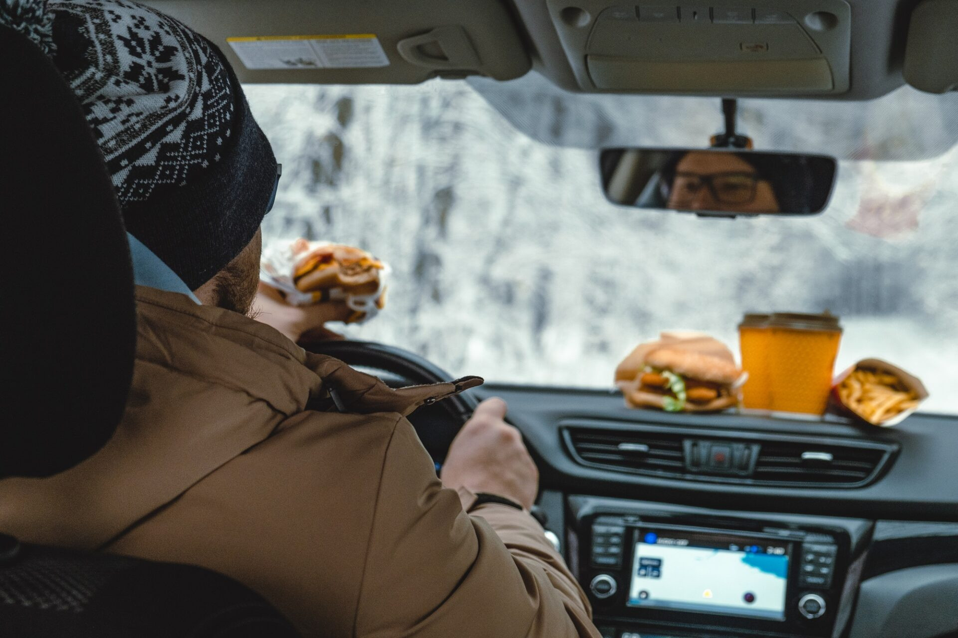 L'homme mange en conduisant une voiture.