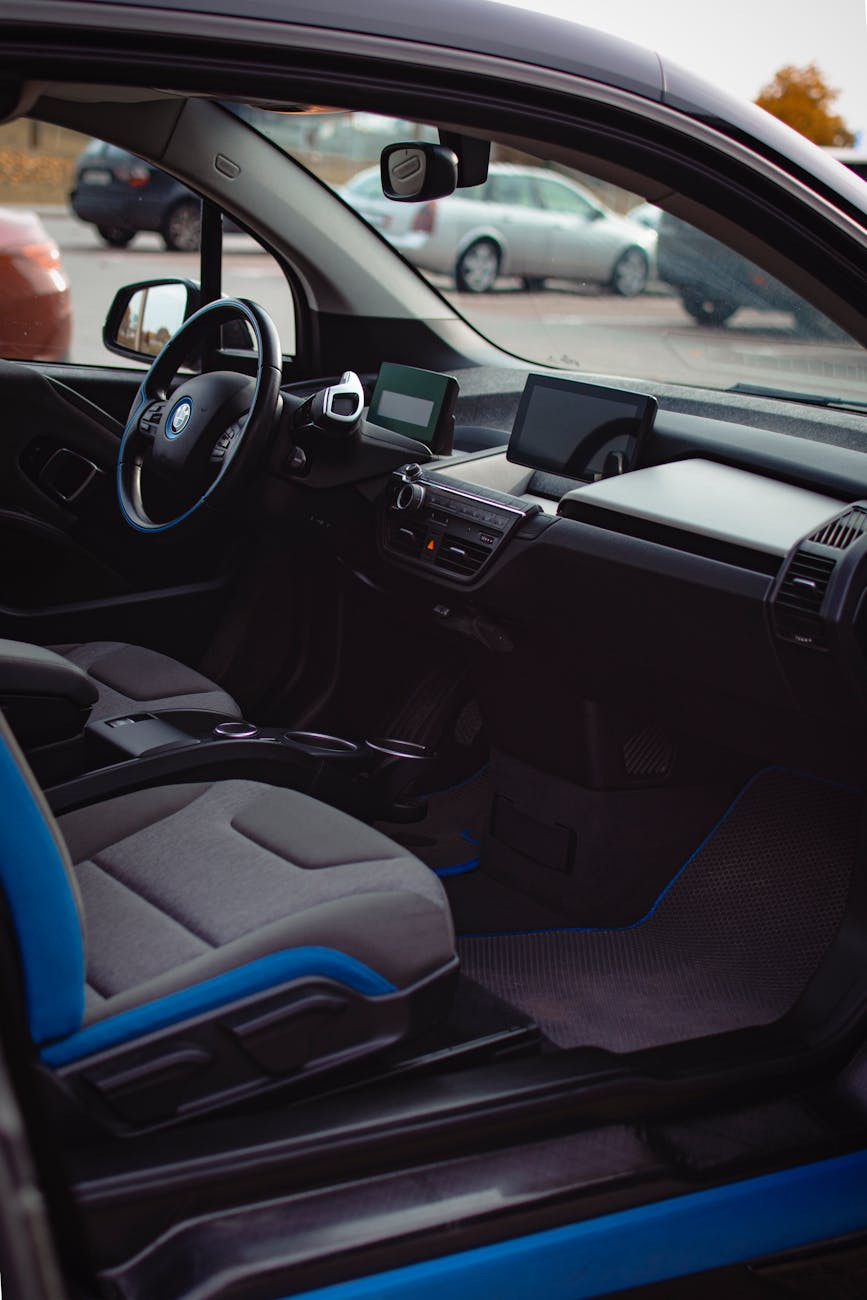 Intérieur luxueux de BMW avec sièges noirs et bleus, tableau de bord et volant à la lumière du jour.